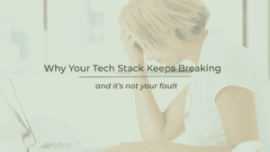 Frustrated woman with head in hand at computer desk.